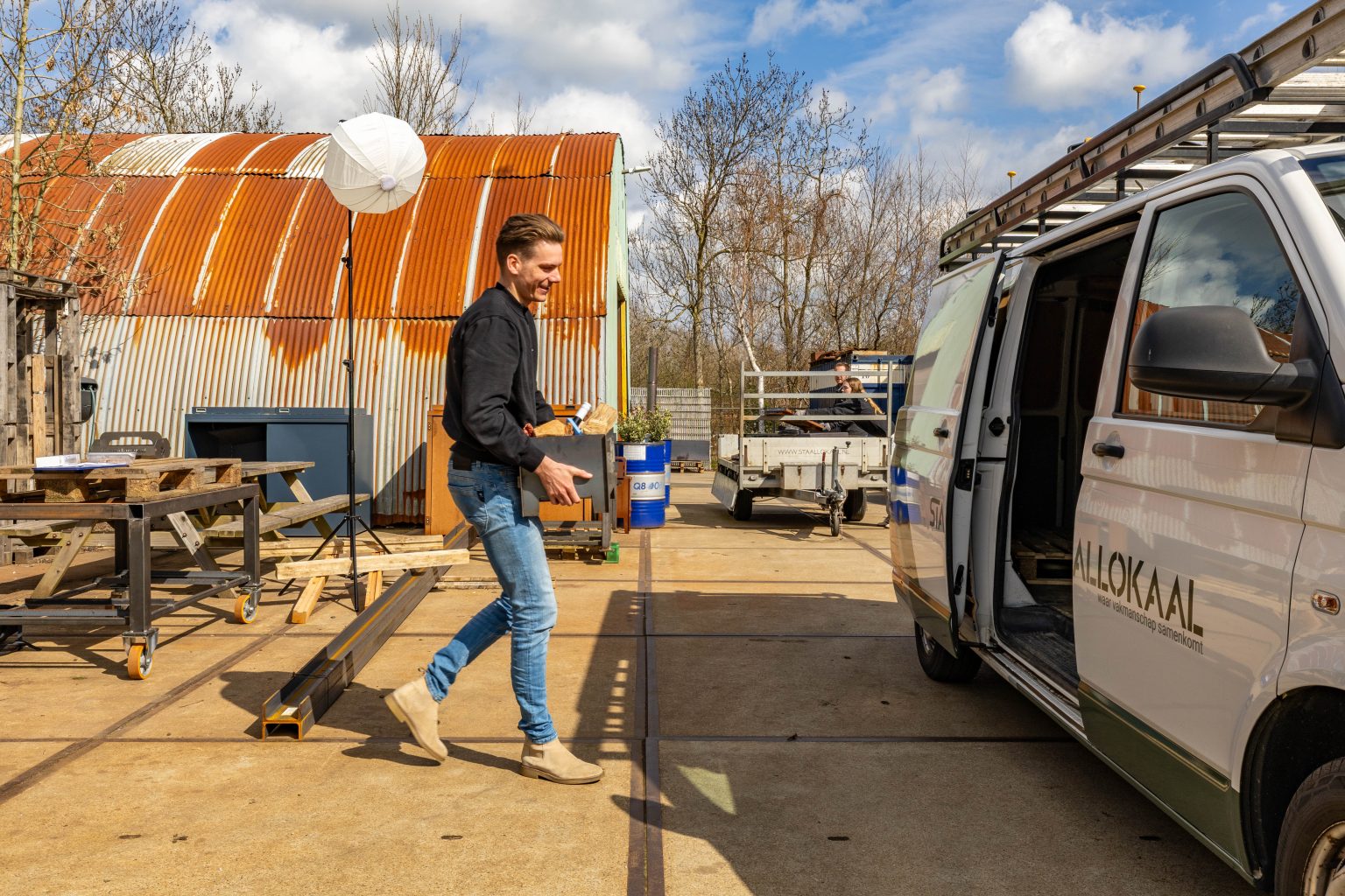 Medewerker van Lokaalverrast loopt met een cadeau naar de bedrijfsbus voor de levering