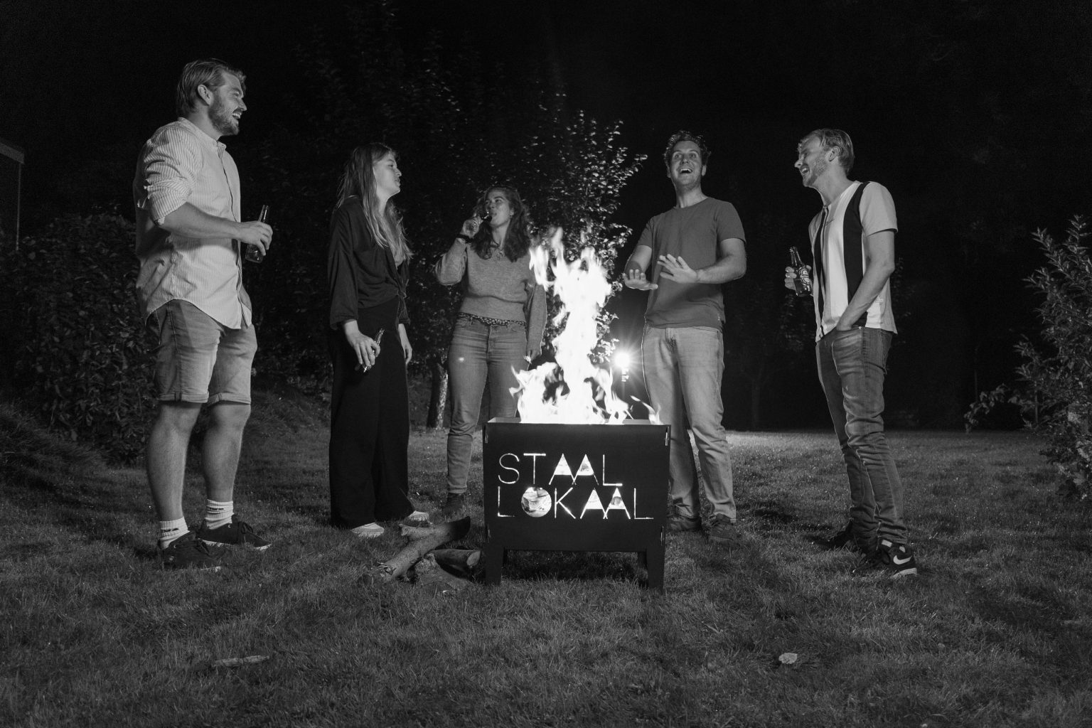 Groep mensen rond de brandende vuurkorf uit een kerstpakket met vuurkorf van Lokaalverrast
