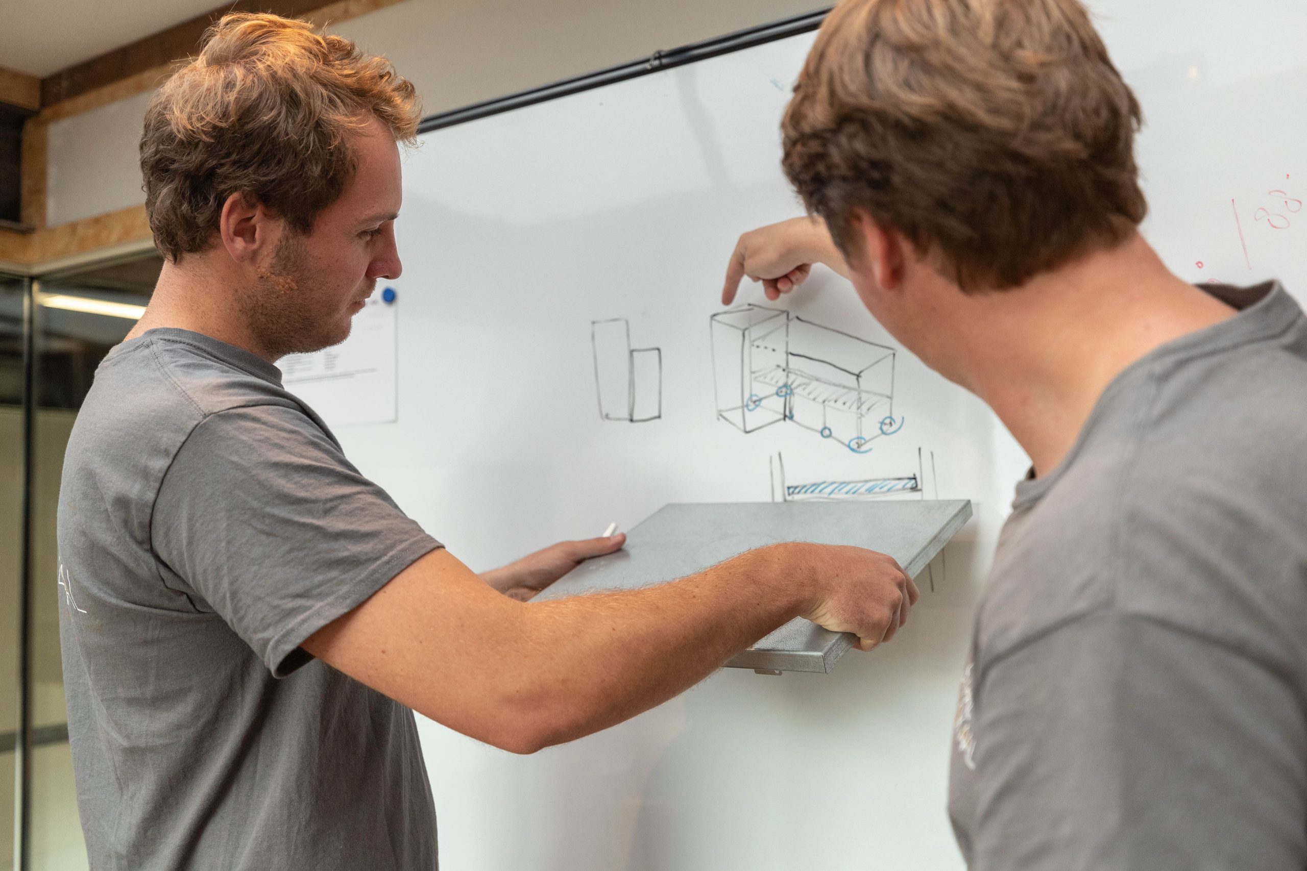 Twee makers van Lokaalverrast schetsen een ontwerp voor lokaal geproduceerde kerstpakketten